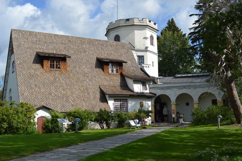 Kesäinen kuva Tarvaspään ateljeehuvilasta sakaraharjaisine torneineen.