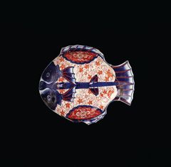 A decorative plate with a fish motif on a black background.