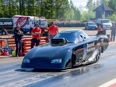 Ari Pietilä ajaa mustalla Top Methanol Funny Car -kiihdytysautolla radalla, valmiina testiä varten.