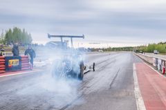 Dragster auto kiihdytysradalla, pakokaasua näkyvissä.
