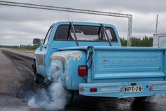 Vanha sininen lava-auto polttaa kumia Vesivehmaan lentokentällä.