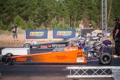 Kaksi junioriautokilpailijaa lähtöviivalla, oranssi ja hopeinen auto.