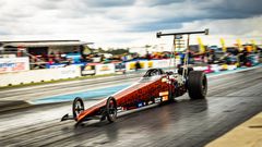 Dragster-auto kiihdyttämässä radalla kilpa-ajotapahtumassa.
