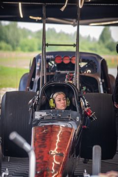 Kuvassa on henkilö moottoriurheiluauton ohjaamossa.