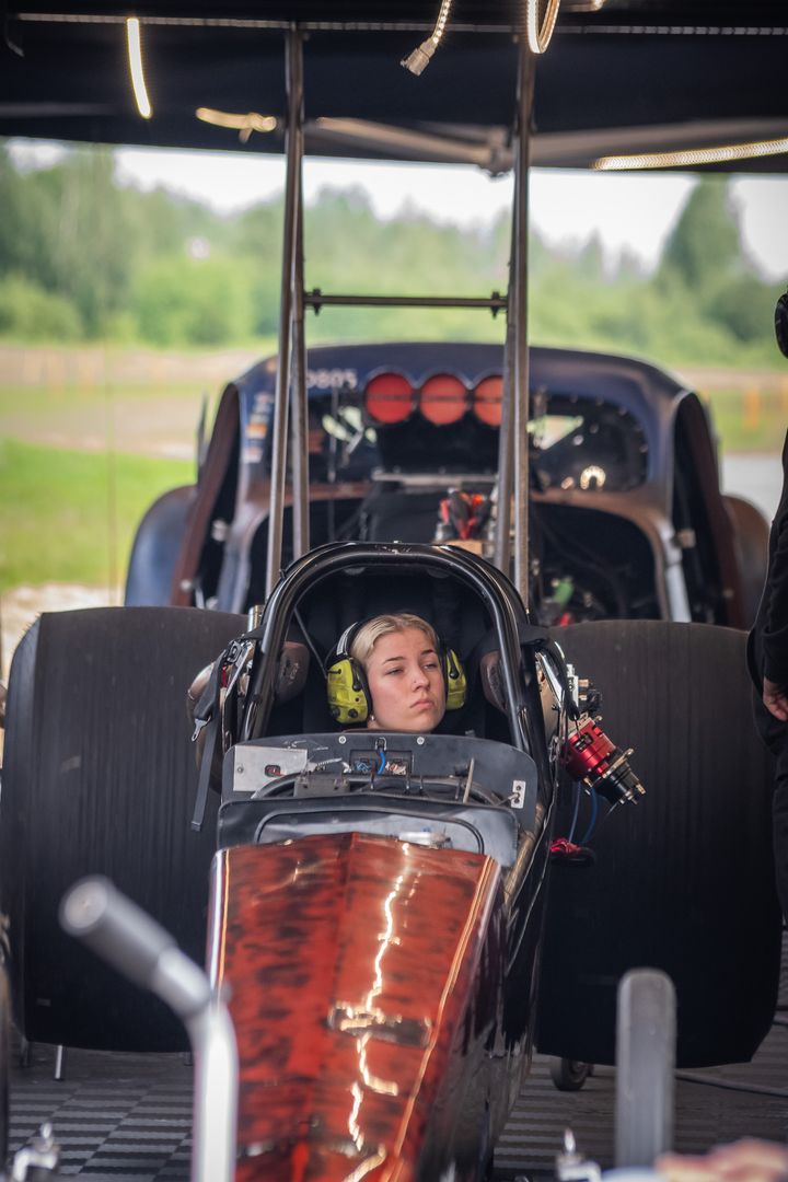 Kuvassa on henkilö moottoriurheiluauton ohjaamossa.