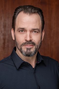 Tuomas Pursio, tumma, parrakas mies katsoo kameraan.