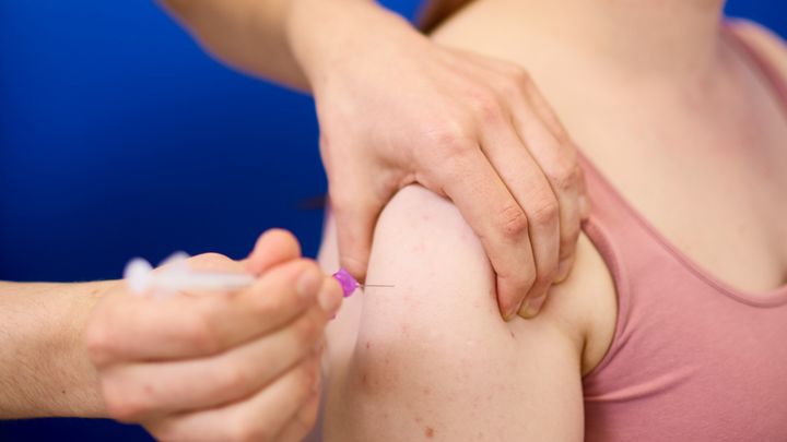 Henkilö saa rokotuksen olkavarteen.