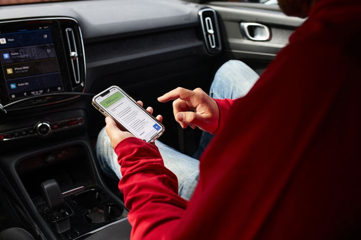 Ihminen käyttää puhelinta autossa.