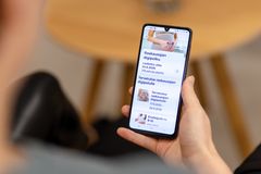Henkilö pitelee älypuhelinta, jonka näytöllä on raskausaiheinen digitaalinen palvelu.