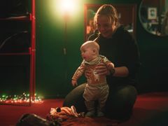 Pieni lapsi ottaa ensiaskeleita vanhemman tuella