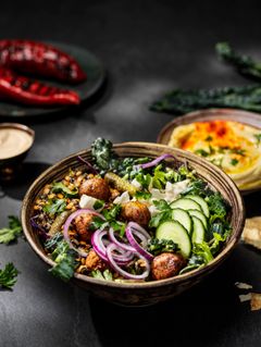 Kulhollinen Picadelin salaattia, sisältäen falafel-pyöryköitä, kurkkua, sipulia ja lehtikaalia.