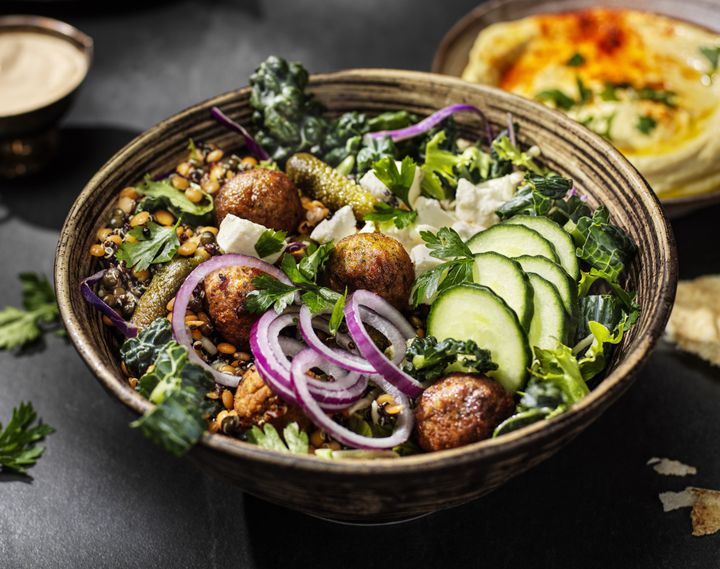 Kulhossa falafelia, viipaloitua kurkkua, punasipulia, fetajuustoa ja lehtikaalia.