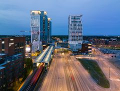 Kaupunkimaisema Helsingistä, jossa näkyvät Redin kauppakeskus ja Kalasataman tornitalot. Etualalla vilkasliikenteinen katu.