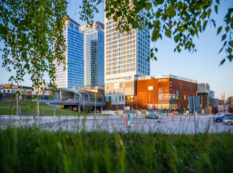 Kuvassa Kauppakeskus Redi ja sen tornitalot, edessä parkkipaikkaa ja katua.