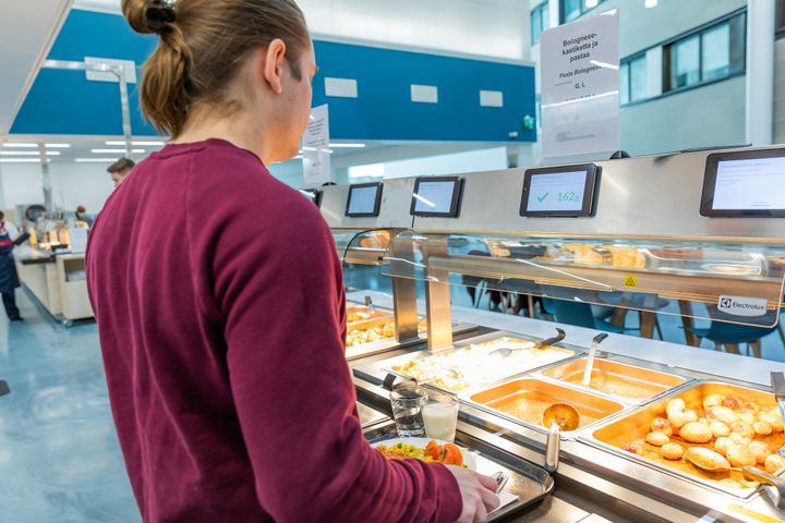 Asiakas valitsee ruokaa itsepalveluravintolan linjastolla