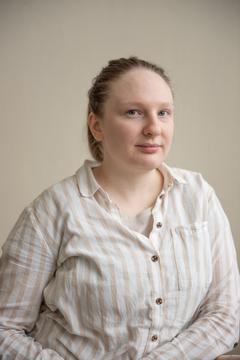 Profiilikuva jossa tutkija Magda Szarek katsoo kohti kameraa, yllään vaalearaitainen kauluspusero, takana vaalean hiekan värinen tausta