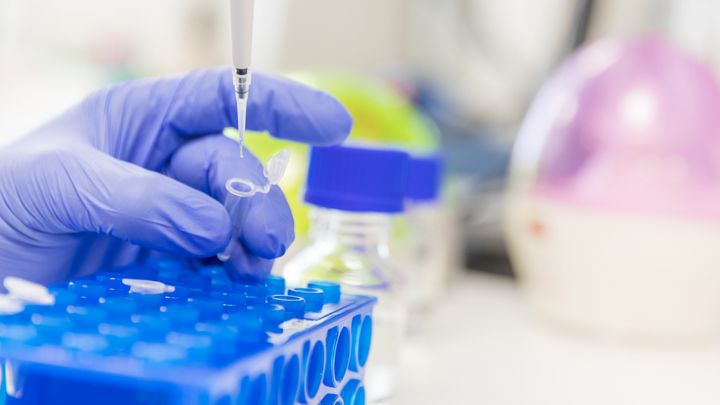 Pipetöintiä laboratoriossa, ihmisestä näkyy vain käsi.