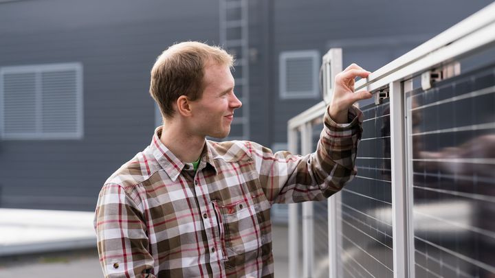 Sami Jouttijärvi aurinkopaneelin vieressä.