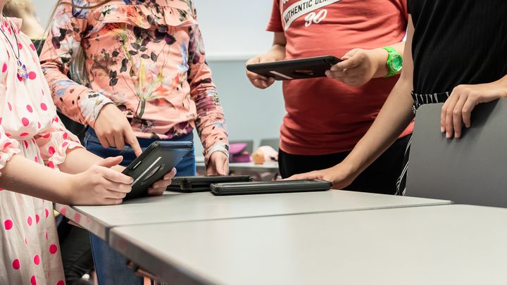 Koululaisia käyttämässä tablettitietokoneita.
