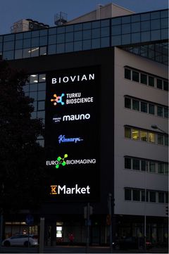 Pimeällä otettu kuva BioCityn seinässä olevista logoista, joissa myös Euro-BioImagingin logo
