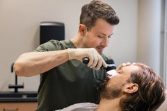 Ammattilainen käyttää dermatoskooppia potilaan ihon tutkimiseen.