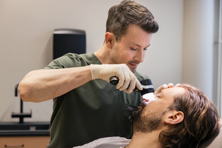 Ammattilainen käyttää dermatoskooppia potilaan ihon tutkimiseen.