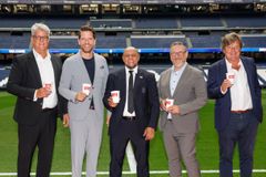Five men standing on a soccer field holding cards, smiling at the camera. From left: Patrick Schenk (responsible for sports partnerships at the Melitta Group), Jero Bentz (member of the management board and great-grandson of company founder Melitta Bentz), Roberto Carlos (soccer legend and youth coach at Real Madrid), Roberto Rojas Martin (responsible for human resources at the Melitta Group), Leonardo Herran López de Montenegro (country manager Melitta Spain).