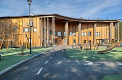 Puinen uudisrakennus, jonka edessä leikkialue. Rakennuksen seinällä kello, keltainen logopallo ja suurella teksti Valteri.