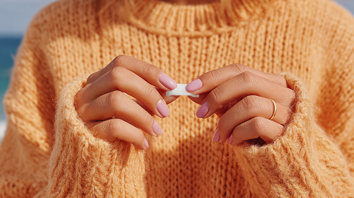 Naisen kädet pitelevät nikotiinipussia - Savuton Nikotiiniala ry, Finlands Nikotinbranch rf