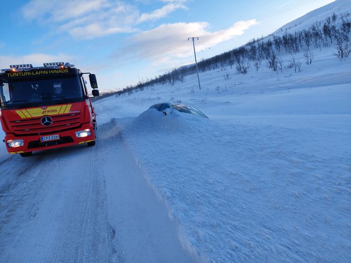 Punainen%20Viking%20hinausauto%20talvisella%20tiell%E4%20vieress%E4%E4n%20ojassa%20lumeen%20peittynyt%20henkil%F6auto.