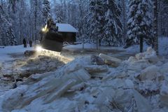 Kaivinkone purkaa hyytötulvaa lumisessa maastossa Kontiolahdella.