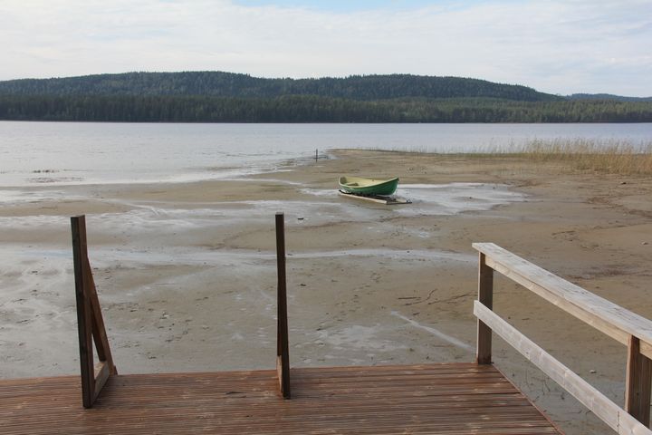 Näkymä Pielisen rannalta Ahvenisella. Etualalla laituri ja rannalla kanootti, taustalla metsäinen maisema.