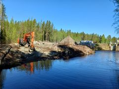 Kätkänjärven rannassa oranssi kaivuri ja kaivuutyömaa.