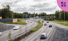 Vaasan yhdystie kaupunkialueella, jolla kulkee useita autoja molempiin suuntiin. Taustalla näkyy metsää ja kauempana silta.