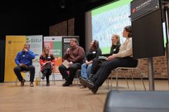 Panelistit lavalla puhumassa.