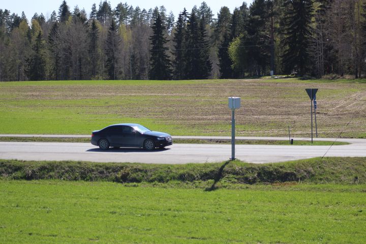 Auto kohtaa nopeuskameran keväisellä maantiellä.