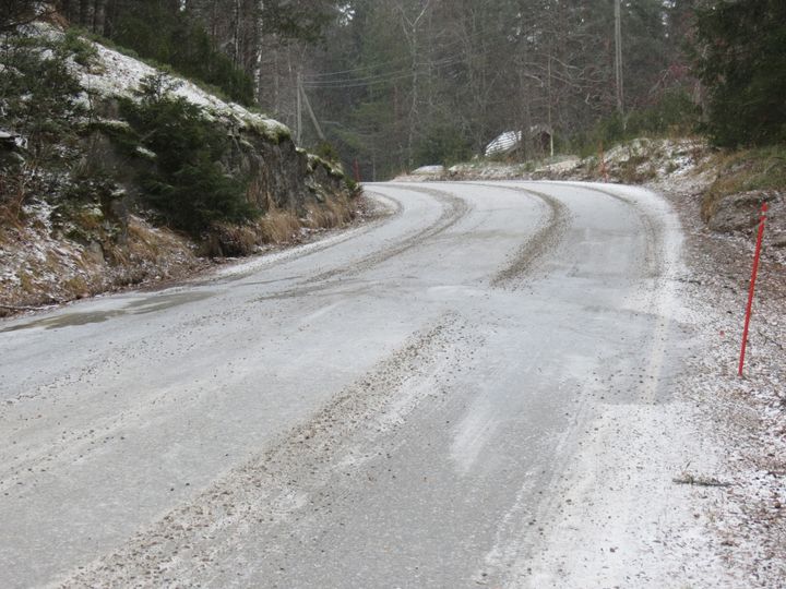 Mutkainen soratie, jolle on satanut hieman lunta.