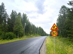 Uusi päällystetty tieosuus ja nopeusrajoitusmerkki 80 km/h metsäisessä ympäristössä.