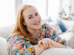 Iida Åfeldt hymyilee ja istuu sohvalla.
