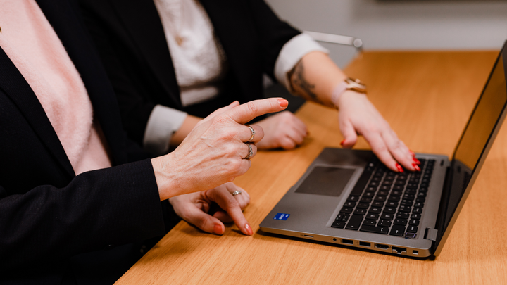 Kvinnor på datorn. Bara händerna syns.