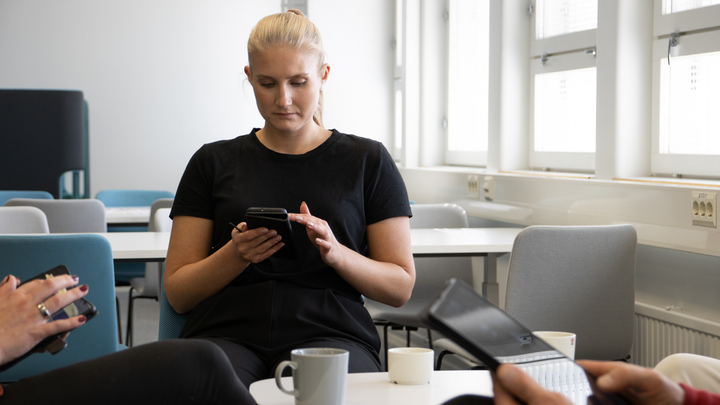 Kvinna tittar på sin telefon.