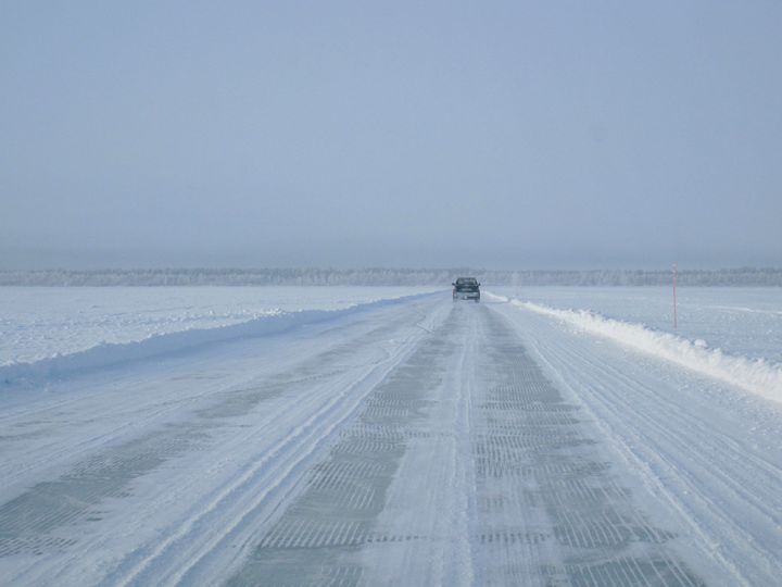 Talvinen näkymä: auto ajaa lumisella Hailuodon jäätiellä.