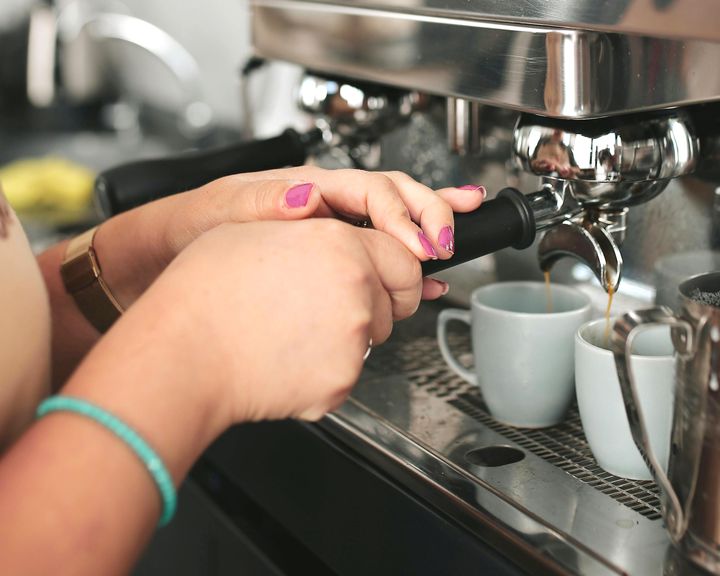 Kahvilatyöntekijä valmistaa kahviannoksia.