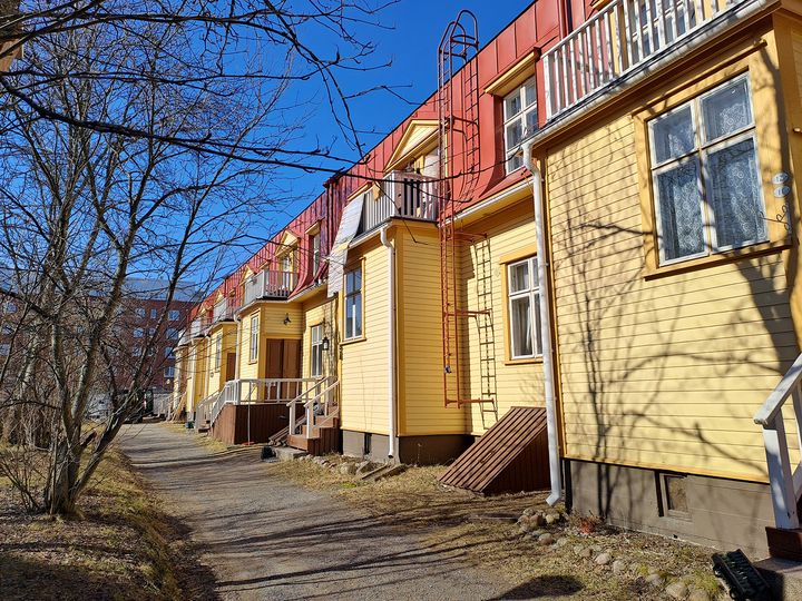 Keltainen%20puurivikerrostalo%2C%20jossa%20punainen%20mansardikatto.
