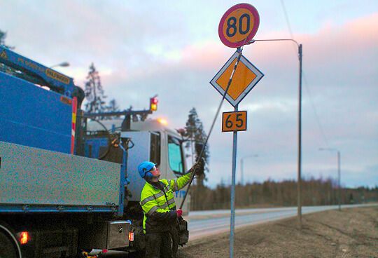urakoitsija vaihtaa liikennemerkin nopeusrajoitusta.