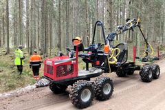 Kuva ajokoneesta ja metsästä, jossa ihmisiä.