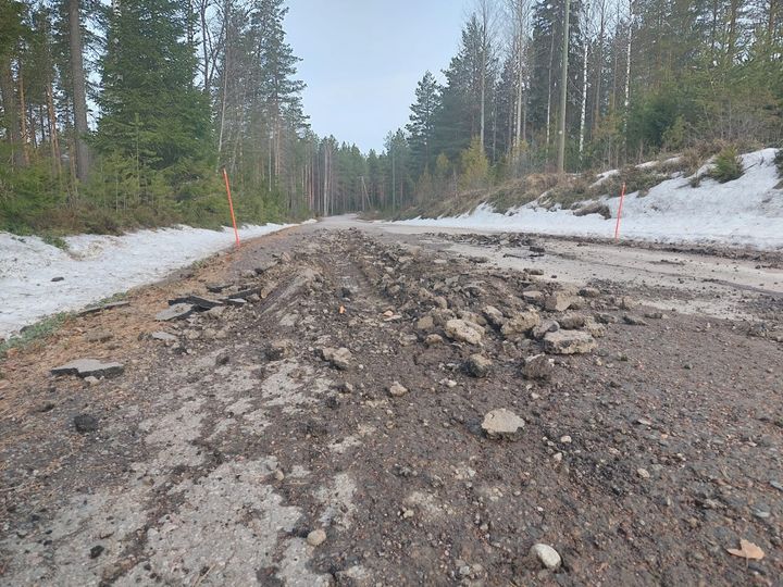 Tien pinnassa vakavia vaurioita, ympärillä metsää ja lunta.