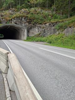 Fiskarin tunnelin pohjoispääty, tie kulkee tunnelin sisään metsäisellä alueella.