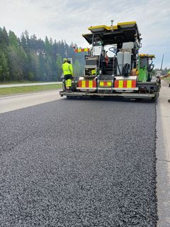 Asfalttikone levittää uutta päällystettä valtatie 4:llä Heinolassa.