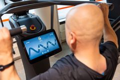 Henkilö seuraa EGYM-laitteen pelillistettyä treeninäkymää harjoituksen aikana.